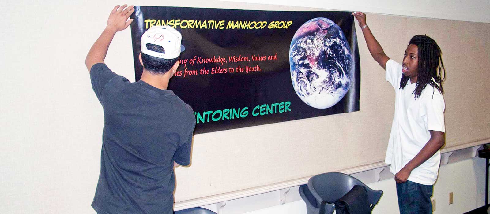 Transformative Manhood Group members hanging sign